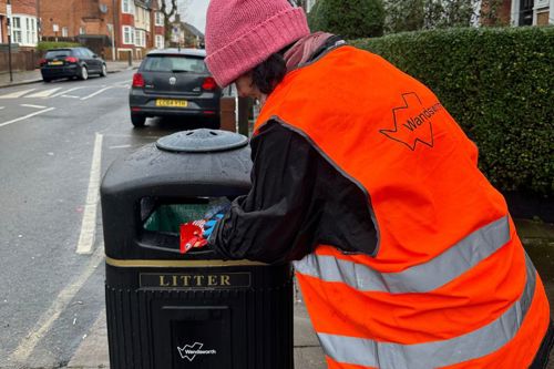 Judi putting rubbish in the new bin in Tooting